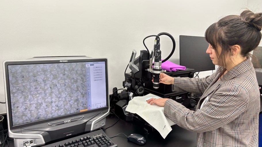 NREL Scientist Kat Knauer examines a weave of a novel biobased textiles using optical microscopy at The North Face’s Denver, Colorado, laboratories.