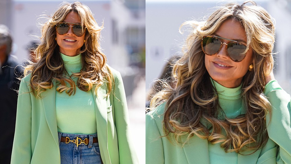 Heidi Klum with volumized big Texas hair, sunglasses, and a green top and blazer