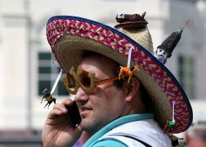 LOUISVILLE, KY - MAY 05: A race fan wearing a hat talks on his phone while standing in the paddock prior to the 138th running of the Kentucky Derby at Churchill Downs on May 5, 2012 in Louisville, Kentucky.  (Photo by Elsa/Getty Images)