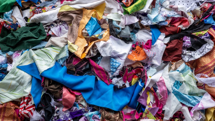 The background of many rag pieces of colorful fabrics which have been left from the sewing and repairing of the clothes by an elderly Thai woman for a long time.