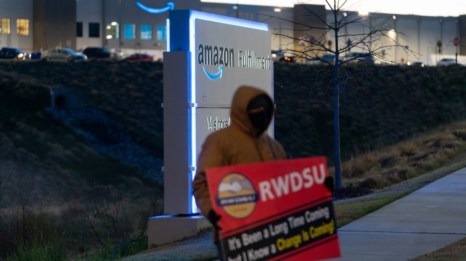 An RWDSU union rep holds a sign outside the Amazon fulfillment warehouse at the center of the first unionization drive in Bessemer, Ala. in March 2021.
