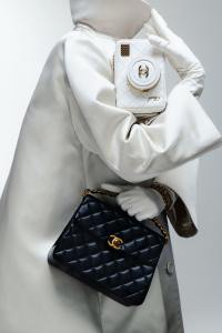 Chanel lambskin handbag with charms and grained calfskin handbag with braided handle; Altuzarra polyester coat; Carolina Amato gloves; Chanel bracelet.