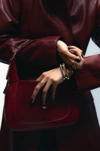Gucci Jackie small shoulder bag; Hermès leather coat; Cartier Trinity ring in 18-karat yellow gold, white gold and rose gold; Cartier Trinity bracelet in 18-karat yellow gold, white gold and rose gold; Chanel ring; Dior 30 Montaigne Jolie ring.