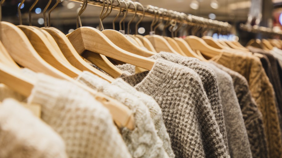 Knit sweaters hanging on a clothes rack.