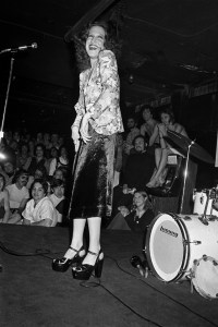 Actress and singer Bette Midler, wearing a velvet skirt and platform shoes, performing for a crowd of gay men at the Continental Club bath house in New York