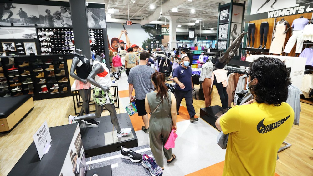 GARDEN CITY, NEW YORK - JULY 10:  Customers wait in line to pay for itemsat Dick's Sporting Goods store at Roosevelt Field Mall which reopened today on July 10, 2020 in Garden City, New York.  Malls across the state were ordered to close March 19, and other businesses deemed nonessential were ordered to close the same week, to help stop the spread of the coronavirus.  The openings follow Gov. Andrew M. Cuomo’s announcement Wednesday that malls outside of New York City can open if they have high-efficiency air filtration systems to help control the spread of the virus.   (Photo by Al Bello/Getty Images)