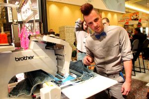 January 8, 2012, Las Vegas,Nevada --- Anthony Ryan Auld, the hottest designer on "Project Runway," demonstrates Brother International's latest high-tech machines at the Brother booth during the 2013 International CES (Consumer Electronics Show) at the Las Vegas Convention Center. --- Christopher Farina (Photo by Chris Farina/Corbis via Getty Images)