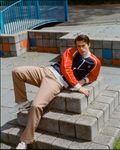 Nicholas Galitzine wears Sergio Tacchini polyester track jacket; Rowing Blazers British wool herringbone pants; Jonas Studio sterling silver bracelet; Lagos black agate ring in sterling silver; Reebok sneakers.