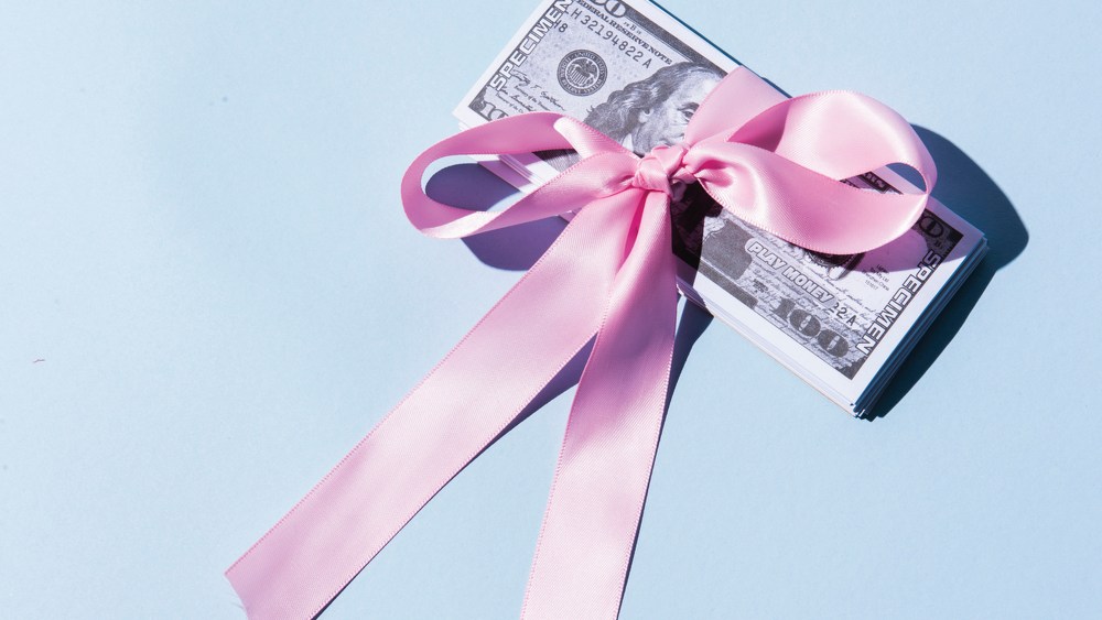 Money with pink ribbon tied around it