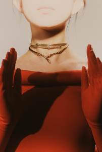 John Hardy 14-karat yellow gold and white diamond spear necklace; Bulgari Serpenti Viper necklace in 18-karat rose gold set with demi-pavé diamonds; Quine Li nylon and red cotton dress for WWD.