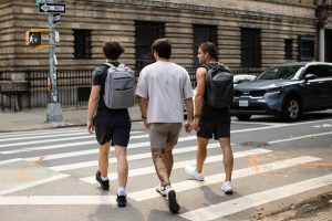 Three guys wear mid-thigh shorts on the streets of New York City.