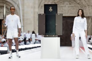 SAINT-DENIS, FRANCE - JULY 26: US rapper, artist and designer Pharell Williams (L) and French actress Laetitia Casta hold the Olympic Torch as part of the 2024 Paris Olympic Games Torch Relay, on the day of the opening ceremony, on July 26, 2024 in Saint-Denis, outside Paris. (Photo by Stephane De Sakutin - Pool/Getty Images)