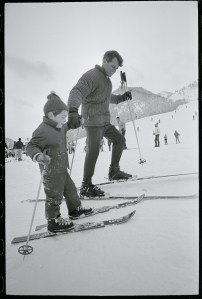 Aspen, Colorado: Senator-elect Robert Kennedy lends a helping hand to John Kennedy Jr. as they climb Ajax Mountain in Aspen, Colorado. The Senator, expert skier, spent the morning skiing with John Jr. December 31, 1964.
