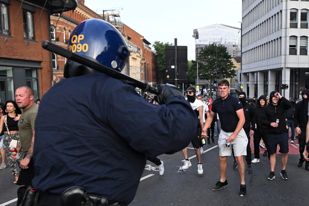 Riot police face protestors in Bristol, southern England, on August 3, 2024 during the 'Enough is Enough' demonstration held in reaction to the fatal stabbings in Southport on July 29. UK police prepared for planned far-right protests and other demonstrations this weekend, after two nights of unrest in several English towns and cities following a mass stabbing that killed three young girls. (Photo by JUSTIN TALLIS / AFP) (Photo by JUSTIN TALLIS/AFP via Getty Images)