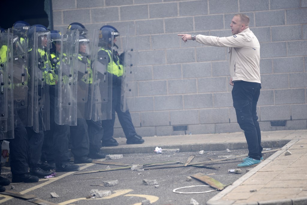 ROTHERHAM, ENGLAND - AUGUST 4: Riot police clash with anti-migration protesters outside of the Holiday Inn Express in Manvers, which is being used as an asylum hotel, on August 4, 2024 in Rotherham, United Kingdom. Yesterday saw widespread violence as Far-right agitators in Liverpool and Manchester rioted and looted shops. Police were attacked and injured and dozens of arrests were made. (Photo by Christopher Furlong/Getty Images)