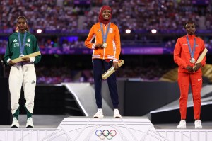 Silver medallist Ethiopia's Tigst Assefa, gold medallist Netherlands' Sifan Hassan and bronze medallist Kenya's Hellen Obiri pose during the podium ceremony for the women's marathon of the athletics event during the closing ceremony of the Paris 2024 Olympic Games at the Stade de France, in Saint-Denis, in the outskirts of Paris, on August 11, 2024.
