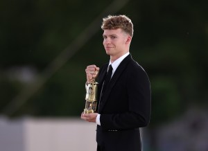 Leon Marchand of Team France carries the Olympic flame during the Closing Ceremony of the Olympic Games Paris 2024  at Stade de France on August 11, 2024 in Paris, France.
