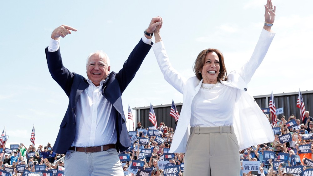 TOPSHOT - US Vice President and 2024 Democratic presidential candidate Kamala Harris and her running mate Minnesota Governor Tim Walz greet supporters as they arrive to a campaign rally in Eau Claire, Wisconsin, August 7, 2024.  (Photo by KAMIL KRZACZYNSKI / AFP) (Photo by KAMIL KRZACZYNSKI/AFP via Getty Images)