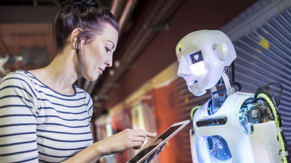 Woman with ipad and robot.