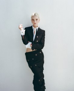 Thom Browne wool cropped jacket with quilted oxford in hunting tartan, cotton quilted oxford, wool crepe low-rise ankle-length hobble skirt and cotton bow tie; Jaeger-LeCoultre Reverso One Duetto; Jean Schlumberger by Tiffany Apollo ear clips in gold with diamonds in platinum.