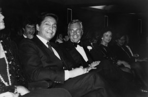 Valentino Garavani and Giorgio Armani are seated in an audience in formal wear