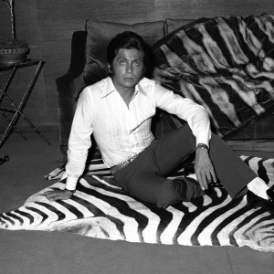 Valentino posing on a zebra skin rug in 1968.