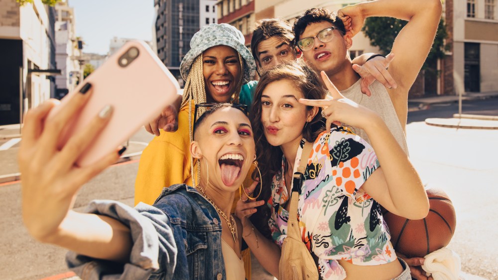 Vibrant selfies. Group of multiethnic young people posing for a selfie together outdoors. Cheerful generation z friends having fun and capturing their happy moments in the city.