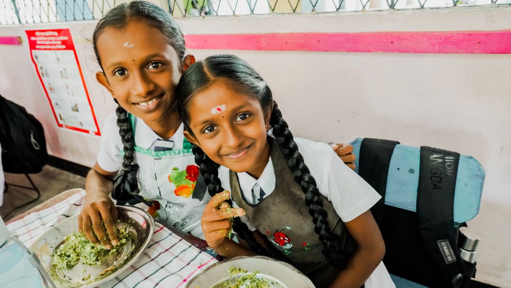 "School meal programme Sri Lanka - students enjoying their morning school meals" .
Morning school meals being served to R.K. Harani and her friend, two Grade 5 students of St. John’s Maha Vidyalaya, Colombo 15. The meal includes US-funded fortified rice provided through the UN World Food Programme.