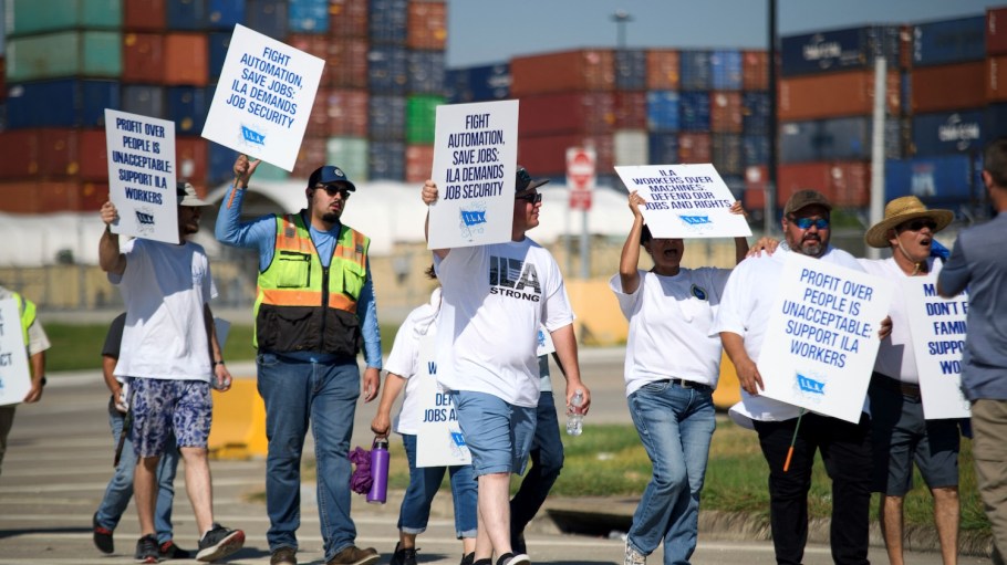 Striking workers hold up signs and march in front of the Bayport Container Terminal in Seabrook, Texas, on October 3, 2024. The International Longshoremen's Association (ILA), 85,000 members strong, has launched its first strike since 1977 after weeks of deadlocked negotiations over a six-year labor agreement.