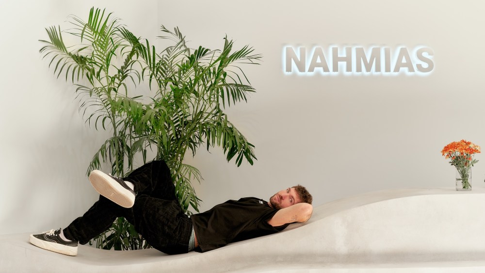 Doni Nahmias lays on a curved concrete bench.