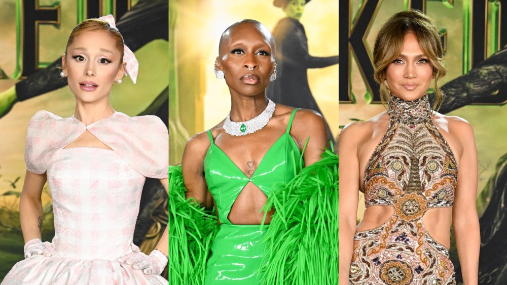 Ariana Grande stands in a pink gingham dress next to Cynthia Erivo in a green dress with a cutout at the front and Jennifer Lopez in a gold halter dress with cutouts at the sides.