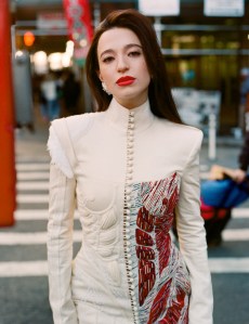 Mikey Madison photographed for WWD at 16 Beaver Studio on December 3, 2024 in New York, New York. Madison wears Thom Browne couture anatomical dress with hand-embroidered beads and Swarovski crystals; Boucheron Wladimir the Cat stud earrings with pink and black lacquer, round diamonds, tsavorites and eyes made from green agates, tsavorites and black sapphires; Chanel metal and glass earring.