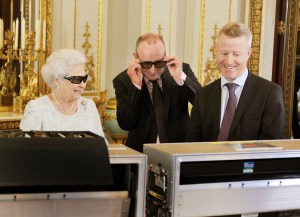 Queen Elizabeth II with producer John McAndrew and director John Bennett (R) watch the recording of her Christmas message to the Commonwealth which is to be broadcast in 3D for the first in the White Drawing Room of Buckingham Palace on December 7, 2012 in London, England.