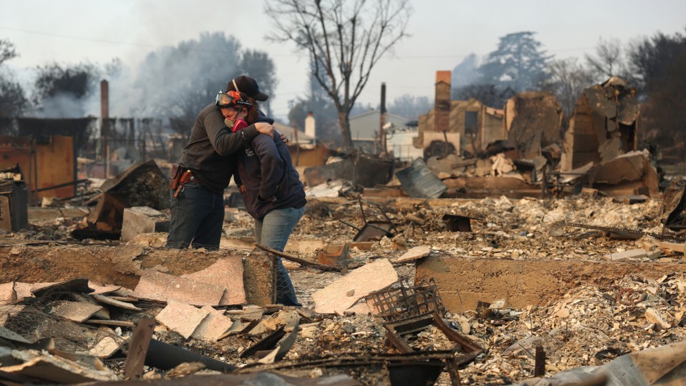 ALTADENA, CALIFORNIA - JANUARY 09: Khaled Fouad (L) and Mimi Laine (R) embrace as they inspect a family member's property that was destroyed by Eaton Fire on January 09, 2025 in Altadena, California. Fueled by intense Santa Ana Winds, the Eaton Fire has grown to over 10,000 acres and has destroyed many homes and businesses. (Photo by Justin Sullivan/Getty Images)