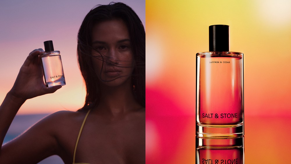 woman holding up a bottle of body mist while wearing a swimsuit, next to a close up shot of set bottle over a yellow and orange background