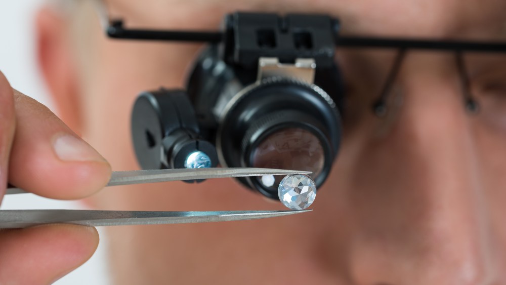 A specialist examining a gemstone.