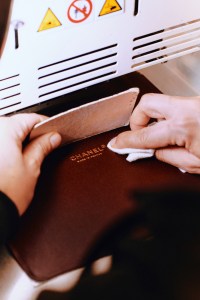 Stamping the gold leaf Chanel logo on the lining of a handbag at Chanel’s AVH factory.