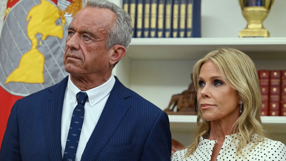 Robert F. Kennedy Jr. (L) and his wife Cheryl Hines listen to US President Donald Trump before a swearing in ceremony for Kennedy as Secretary of Health and Human Services in the Oval Office of the White House in Washington, D.C., on Feb. 13, 2025.