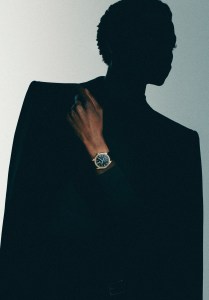 Rolex Oyster Perpetual 1908 39mm watch in 18-karat yellow gold with a leather strap; Celine Homme by Hedi Slimane tailcoat with braided trims in wool and mohair gabardine and wool high collar sweater; Dior wool twill pants; Celine Homme by Hedi Slimane belt.