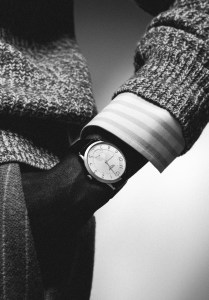 Slim d’Hermès watch with steel case and noir alligator strap; Loro Piana virgin wool and silk shirt under Brooks Brothers wool English rib sweater; Burberry wool-blend trousers.