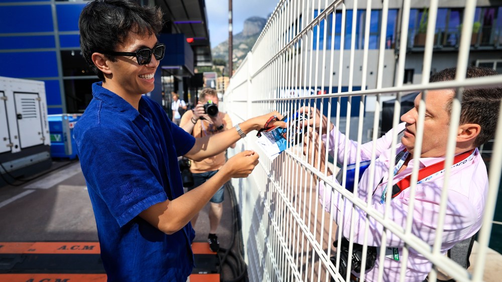 MONTE-CARLO, MONACO - MAY 23: Alexander Albon of Thailand and Williams signs a photo for a gan through the paddock fence during previews ahead of the F1 Grand Prix of Monaco at Circuit de Monaco on May 23, 2024 in Monte-Carlo, Monaco. (Photo by Kym Illman/Getty Images)