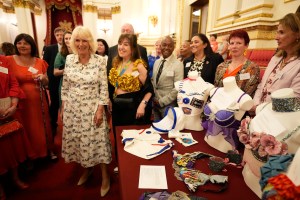 LONDON, ENGLAND - APRIL 30: Queen Camilla stands with Nina Barough (in yellow) from charity Walk The Walk during a reception in celebration of community-based initiatives raising awareness about cancer and supporting those living with cancer at Buckingham Palace on April 30, 2025 in London, England.  (Photo by Andrew Matthews - WPA Pool/Getty Images)