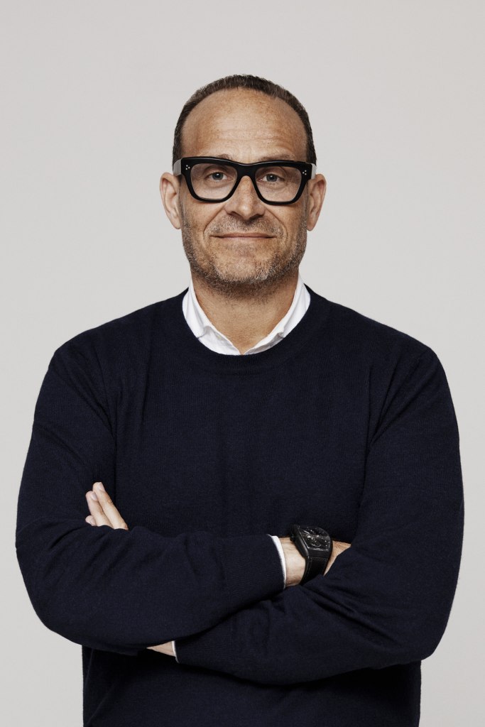 Mark Metrick in black sweater and glasses.