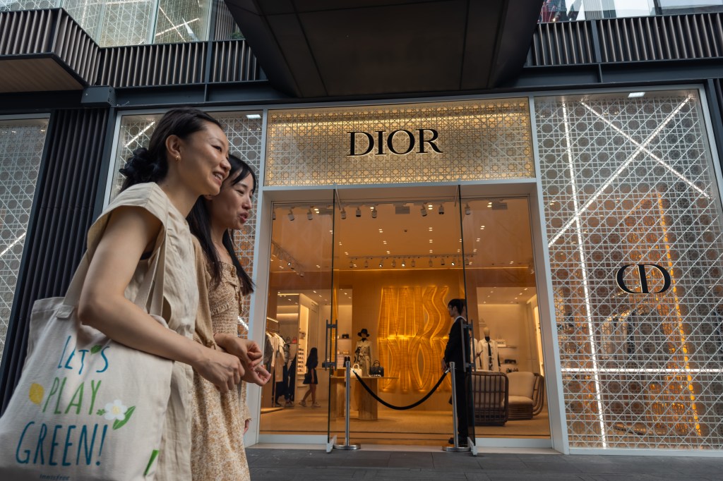 Chinese shoppers walk past a Dior store in Chengdu.