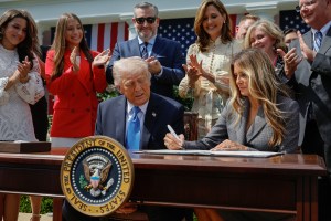 WASHINGTON, DC - MAY 19: U.S. President Donald Trump looks on as first lady Melania Trump signs the TAKE IT DOWN Act during a ceremony with deepfake victims, Sen. Ted Cruz (R-TX ) (C) and other members of Congress in the Rose Garden of the White House on May 19, 2025 in Washington, DC. The Tools to Address Known Exploitation by Immobilizing Technological Deepfakes on Websites and Networks (TAKE IT DOWN) Act was a priority for the first lady, who traveled to Capitol Hill to lobby lawmakers and show her support for the legislation, which addresses non-consensual intimate imagery, or "revenge porn," or artificial intelligence deepfakes posted online and to social media. (Photo by Chip Somodevilla/Getty Images)