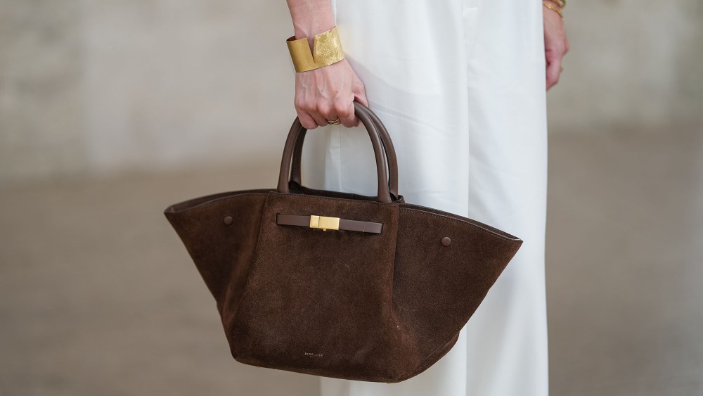 a woman carrying a suede demellier london bag in paris
