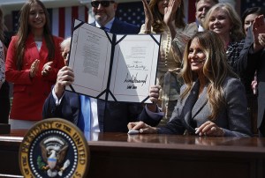 WASHINGTON, DC - MAY 19: U.S. President Donald Trump, seated next to first lady Melania Trump and joined by lawmakers and victims of AI deepfakes and revenge porn, holds a copy of the TAKE IT DOWN Act during a signing ceremony in the Rose Garden of the White House on May 19, 2025 in Washington, DC. The first lady made the Tools to Address Known Exploitation by Immobilizing Technological Deepfakes on Websites and Networks (TAKE IT DOWN) Act a priority, traveling to Capitol Hill to lobby lawmakers and show her support for the legislation, which addresses non-consensual intimate imagery, or "revenge porn," and artificial intelligence deepfakes posted online and to social media. (Photo by Chip Somodevilla/Getty Images)