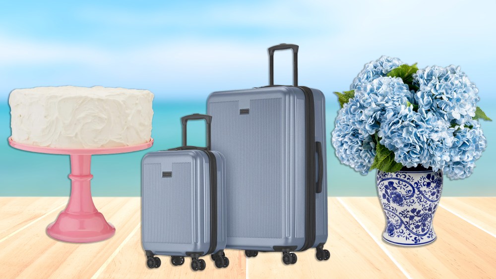 a cake stand, luggage, and a vase full of hydrangeas over a blue sky, sea, and boardwalk background