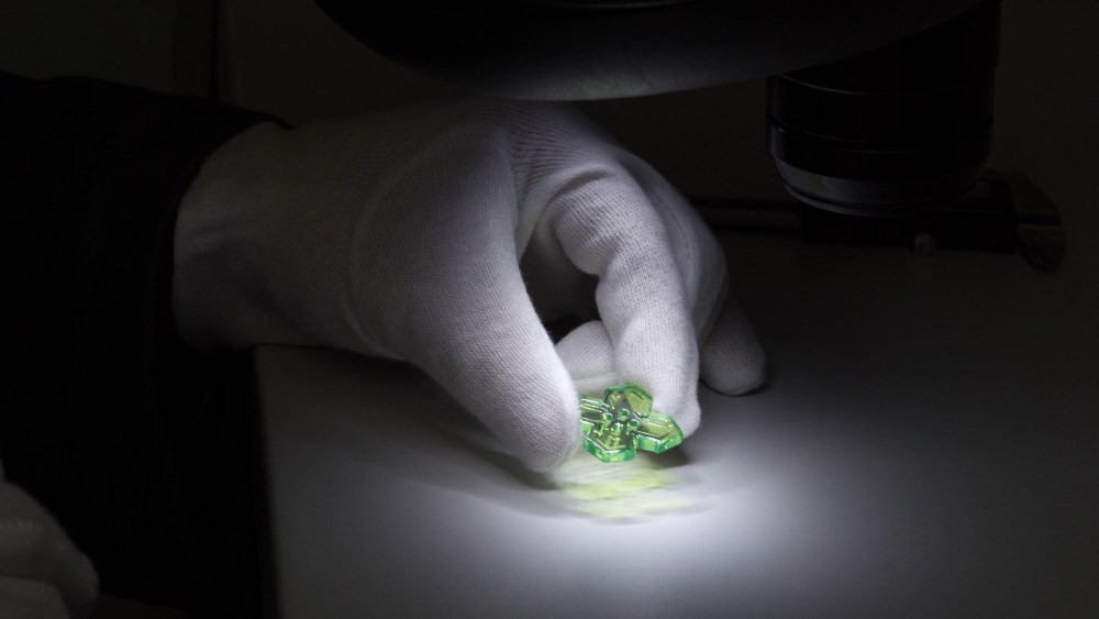 A quality check of a hand-crafted fluorescent button for Autista.