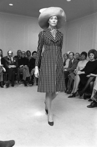 A model wearing a striped coat with a silk scarf and a wide brimmed hat in the Bill Blass Ready to Wear Spring/Summer 1972 show (Photo by Fairchild Archive/Penske Media via Getty Images)